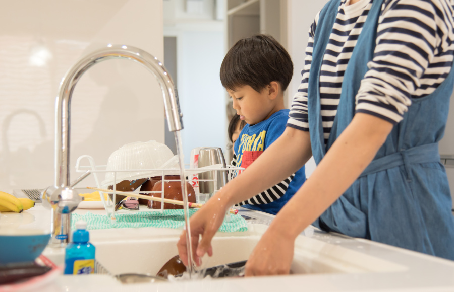 Boy with lady washing dishes